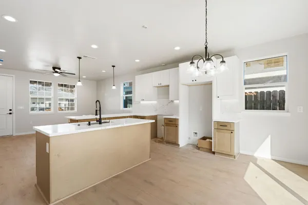 a large kitchen with kitchen island granite countertop a sink a counter space appliances and cabinets