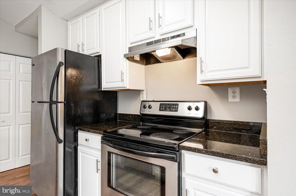 9901 Boysenberry Way, Unit 24018 Gaithersburg, MD 20879 - Photo 11 of 26 a kitchen with stainless steel appliances granite countertop a stove and a refrigerator with white cabinets