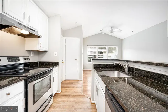 a kitchen with granite countertop a sink and stove top oven
