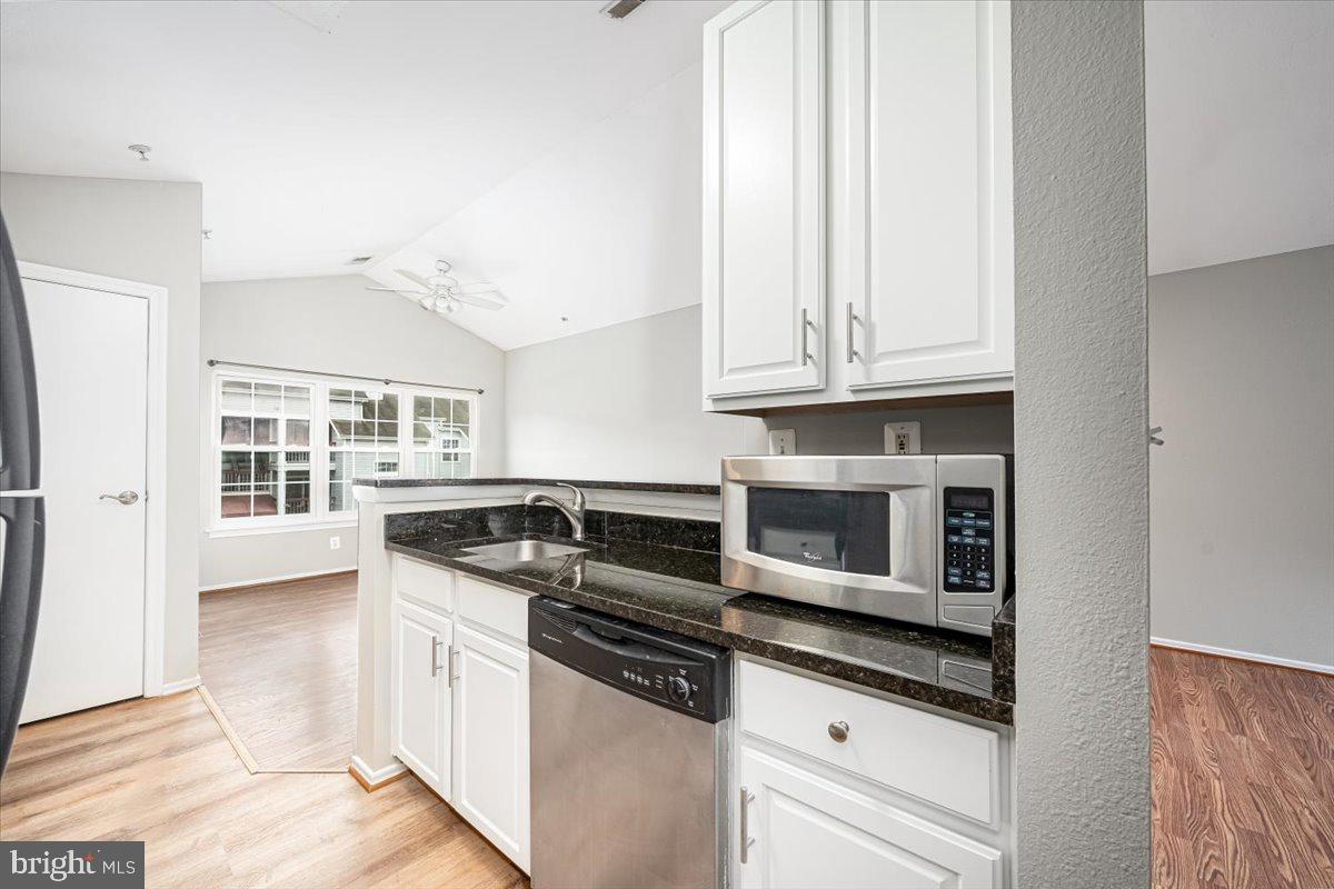 9901 Boysenberry Way, Unit 24018 Gaithersburg, MD 20879 - Photo 13 of 26 a kitchen with stainless steel appliances granite countertop a stove and a white cabinets