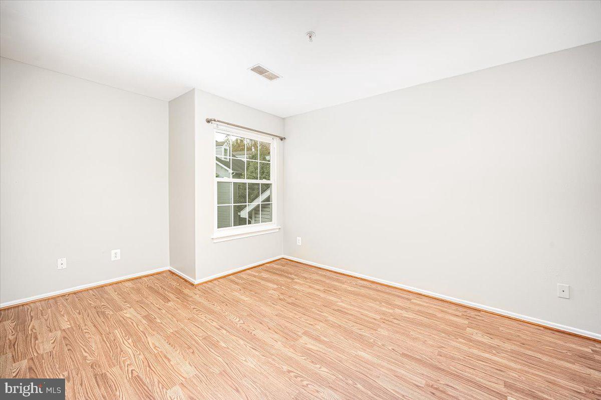 9901 Boysenberry Way, Unit 24018 Gaithersburg, MD 20879 - Photo 14 of 26 a view of empty room with wooden floor and fan