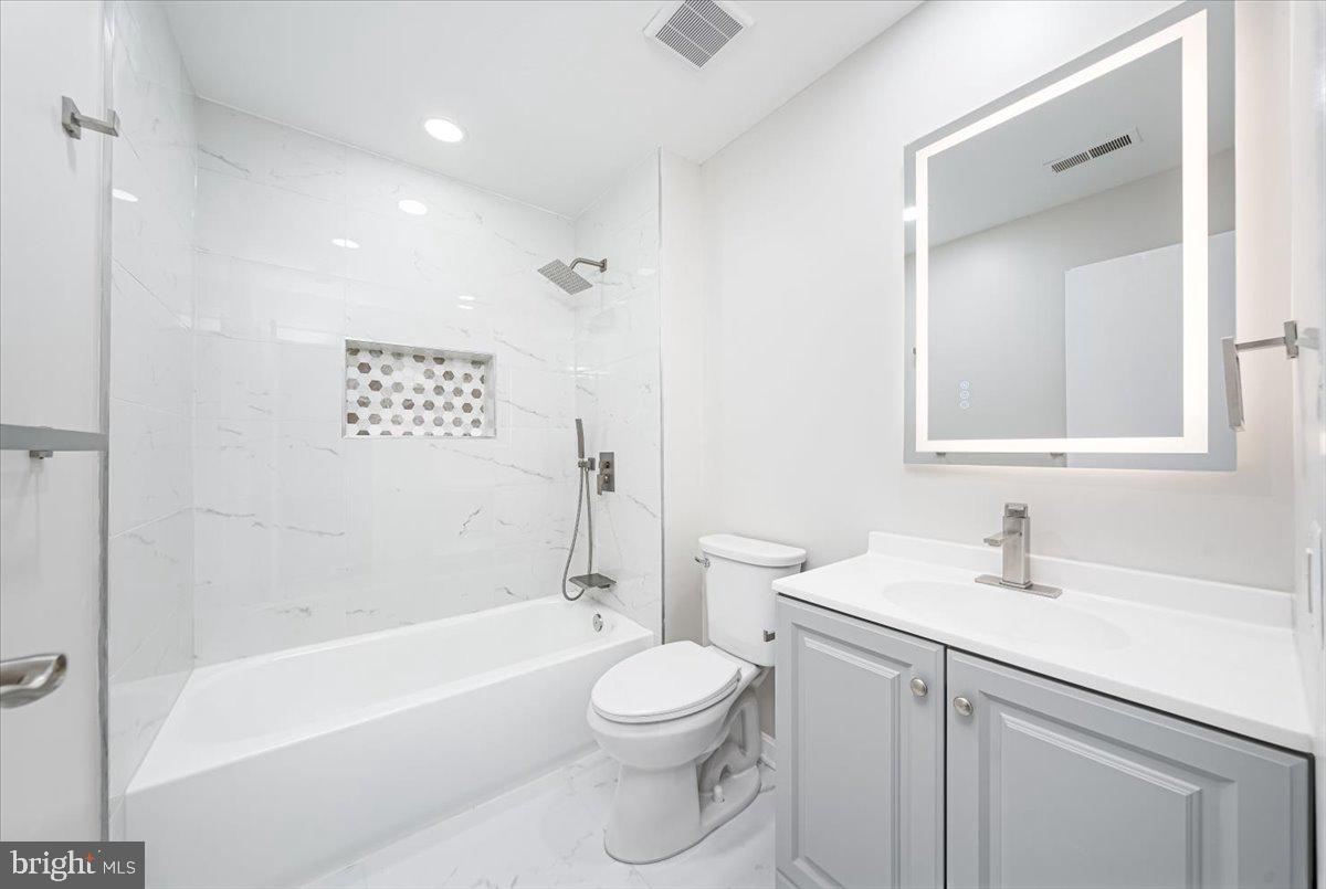 9901 Boysenberry Way, Unit 24018 Gaithersburg, MD 20879 - Photo 16 of 26 a bathroom with a toilet a sink and a bathtub