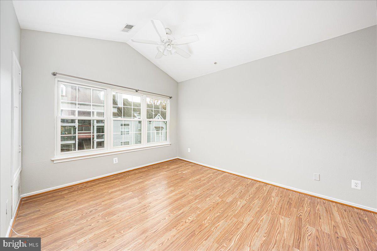 9901 Boysenberry Way, Unit 24018 Gaithersburg, MD 20879 - Photo 3 of 26 a view of an empty room with wooden floor and a window