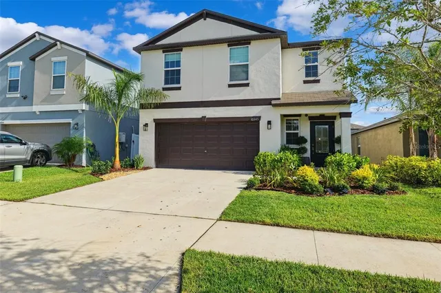 a front view of a house with a yard and garage