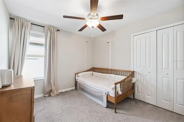 a bed sitting in a spacious bedroom next to a window