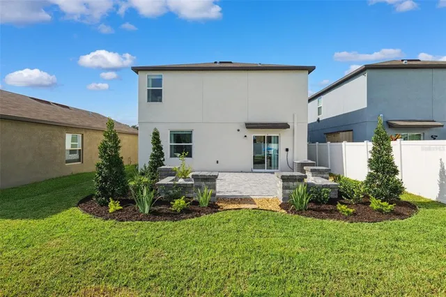 a view of a house with backyard and a garden