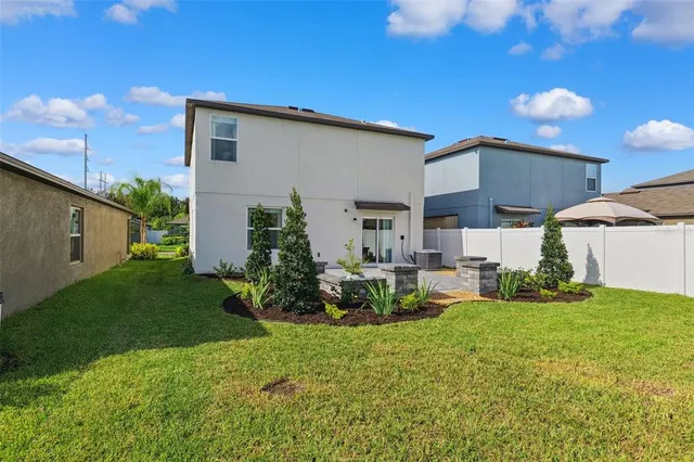 a view of a house with backyard and sitting area