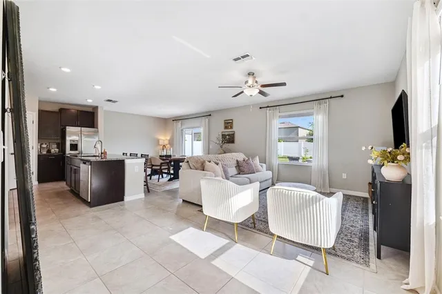 a living room with furniture and view of kitchen