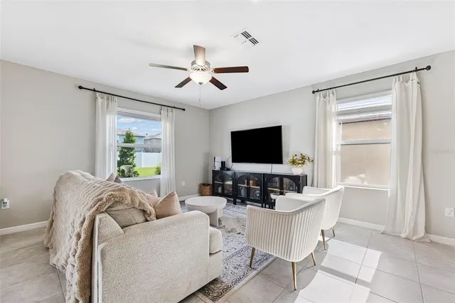 a living room with furniture a flat screen tv and a large window