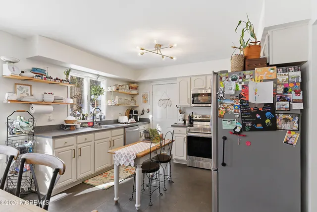 a kitchen with stainless steel appliances kitchen island granite countertop a refrigerator and microwave