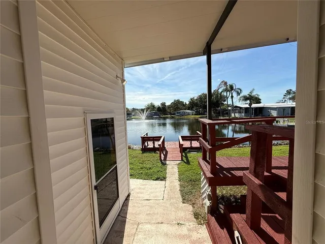 a view of a house with wooden deck and furniture