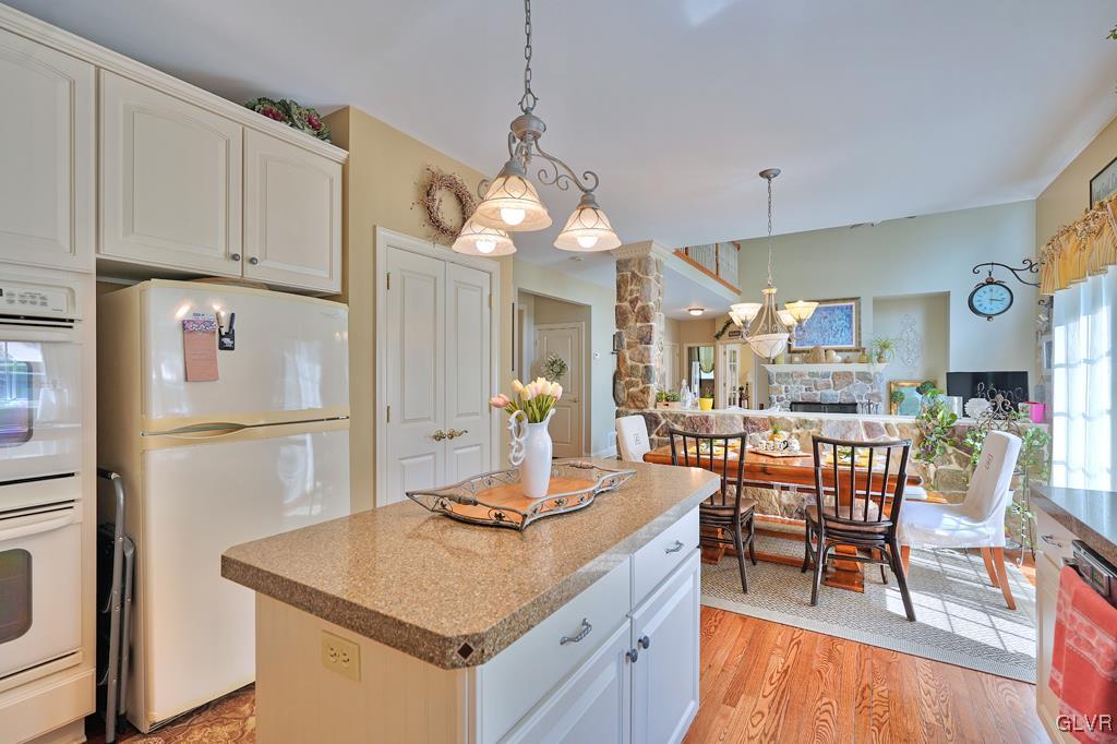 3280 Gun Club Road Nazareth, PA 18064 - Photo 8 of 34 a kitchen with stainless steel appliances granite countertop a stove refrigerator a dining table and chairs with wooden floor