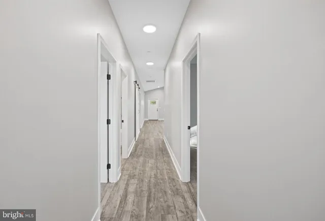 a view of a hallway with wooden floor