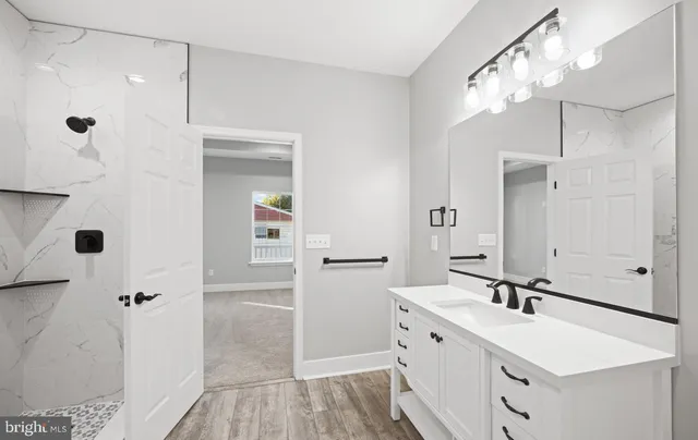 a bathroom with a double vanity sink a mirror and shower