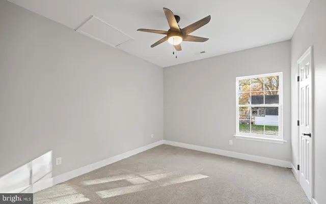 an empty room with windows and ceiling fan