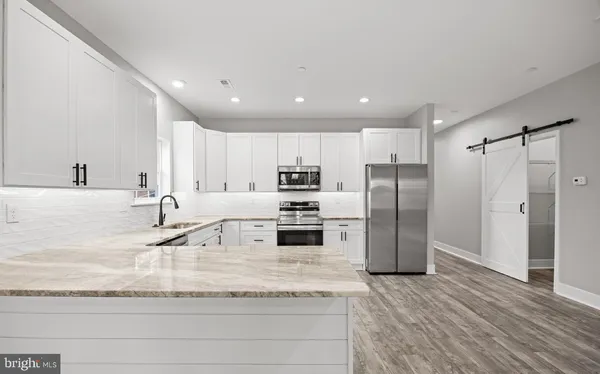 a kitchen with stainless steel appliances granite countertop a refrigerator and a sink