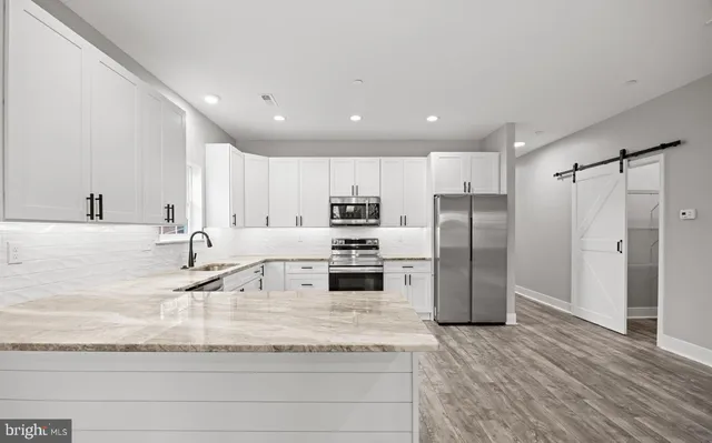 a kitchen with stainless steel appliances granite countertop a refrigerator and a sink