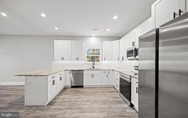 a kitchen with stainless steel appliances granite countertop a stove top oven a sink dishwasher and a refrigerator