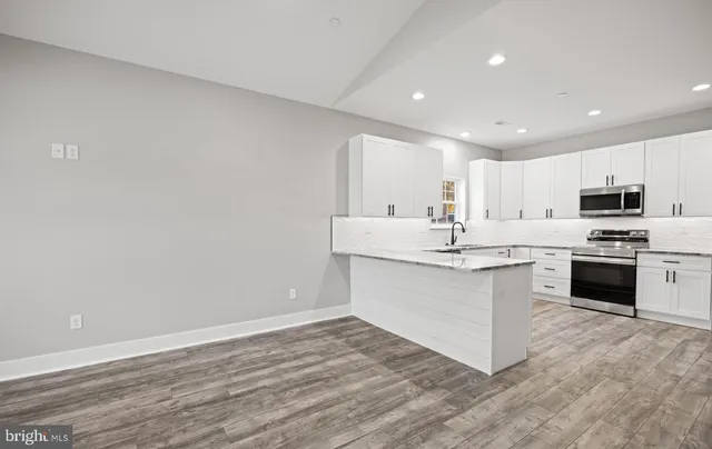 a kitchen with granite countertop white cabinets and stainless steel appliances