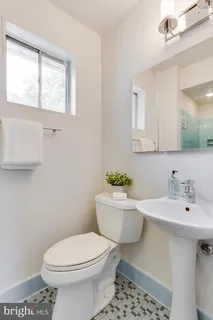 a bathroom with a sink a toilet and mirror