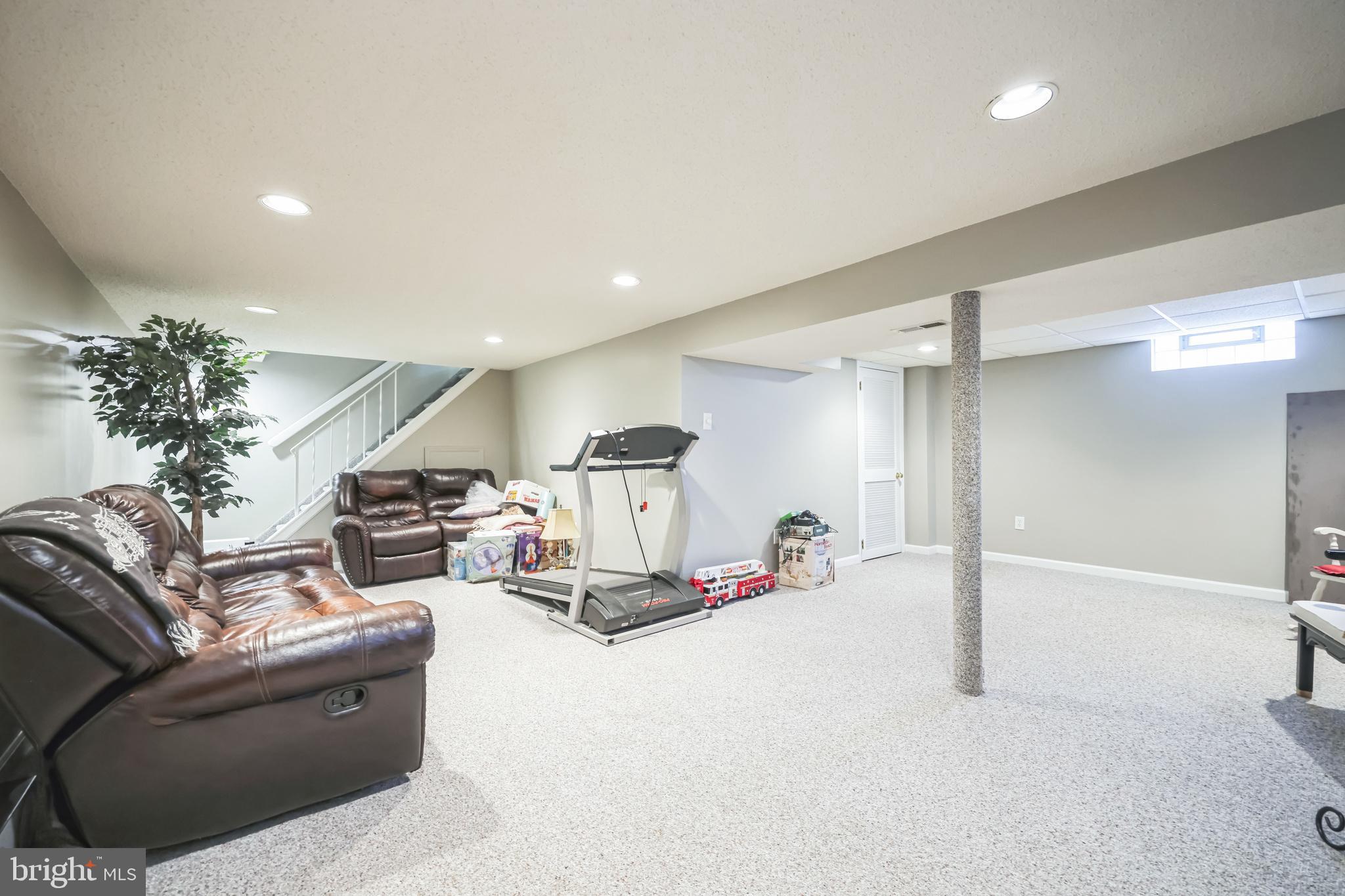 550 Sherry Drive Runnemede, NJ 08078 - Photo 22 of 28 a living room with furniture gym equipment and a chandelier