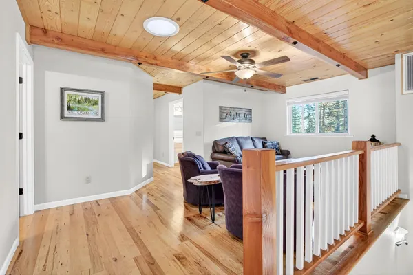 a living room with furniture a flat screen tv and a floor to ceiling window