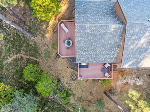 an aerial view of a house with a yard and large trees