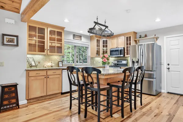 a kitchen with stainless steel appliances granite countertop a stove a sink and a refrigerator