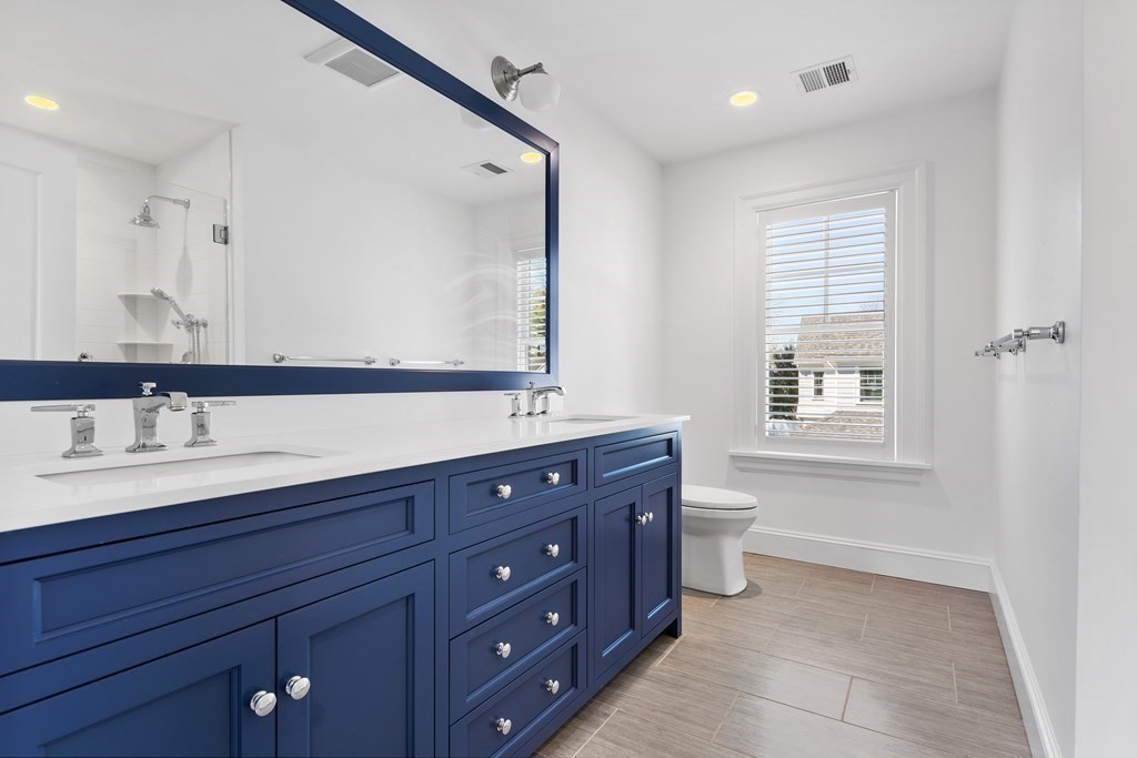 19 Longmeadow Road Wellesley, MA 02482 - Photo 20 of 34 a spacious bathroom with a granite countertop double vanity sink a mirror and a bathtub