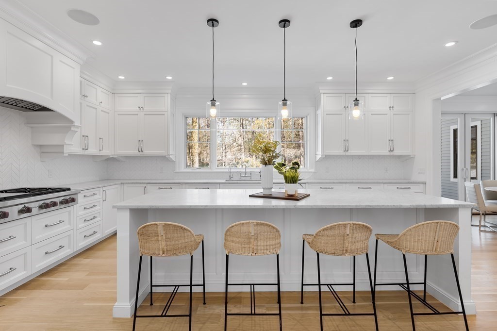 19 Longmeadow Road Wellesley, MA 02482 - Photo 5 of 34 a kitchen with stainless steel appliances granite countertop a table chairs stove and white cabinets