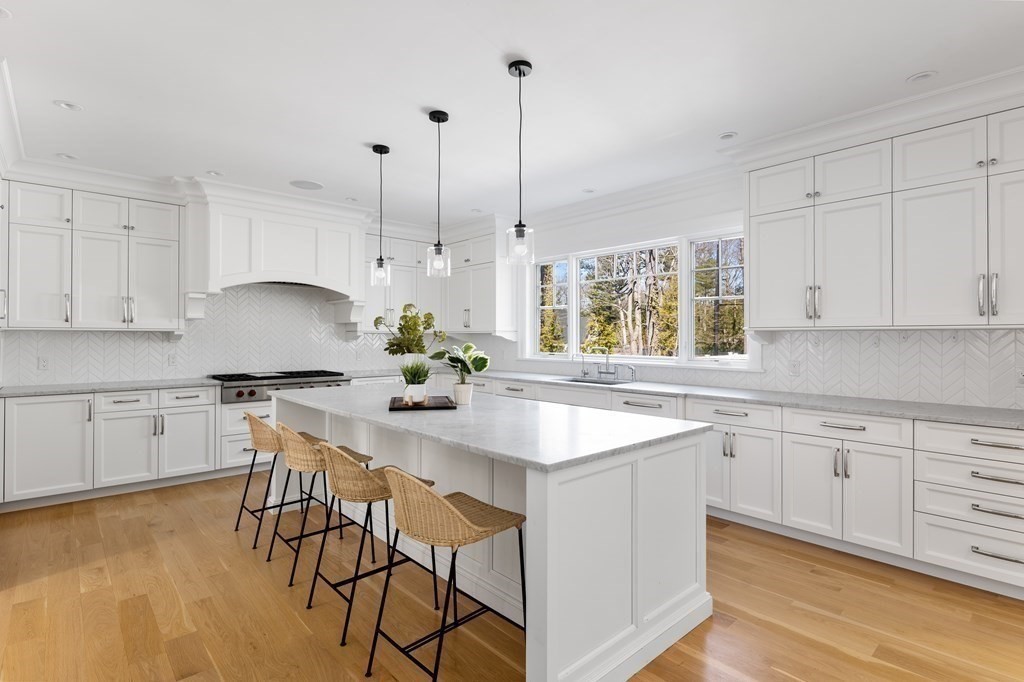 19 Longmeadow Road Wellesley, MA 02482 - Photo 6 of 34 a kitchen with stainless steel appliances granite countertop a stove a sink a oven a dining table and chairs with white cabinets