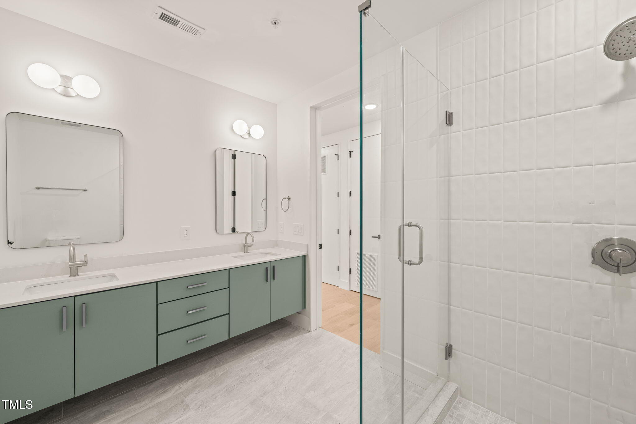 29 Enterprise Street, Unit 207 Raleigh, NC 27607 - Photo 11 of 36 a bathroom with a double vanity sink mirror and shower