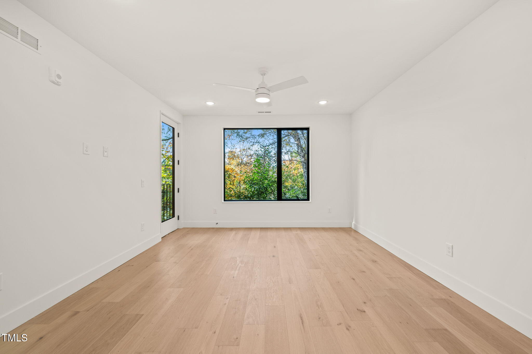 29 Enterprise Street, Unit 207 Raleigh, NC 27607 - Photo 7 of 36 an empty room with wooden floor and windows