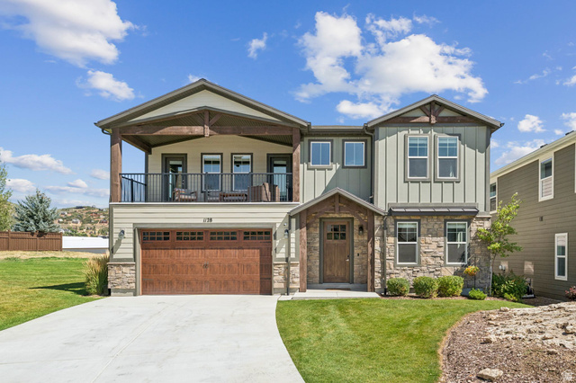 1128 Springer View Loop Midway, UT 84049 - Photo 1 of 1 Craftsman house featuring stone siding, a front lawn, concrete driveway, and board and batten siding