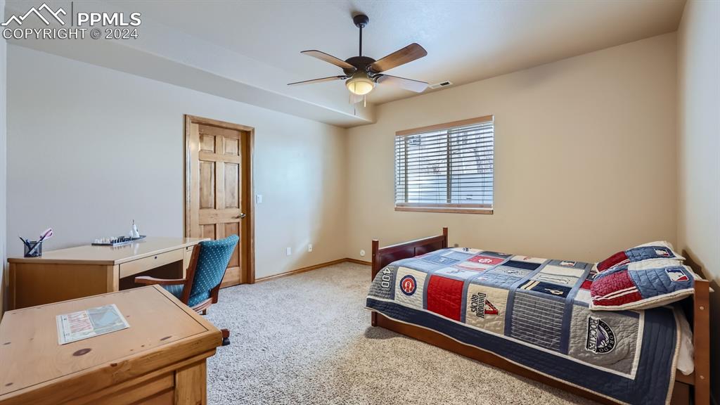 2644 Cinnabar Road Colorado Springs, CO 80921 - Photo 14 of 22 a bedroom with a bed and a chandelier