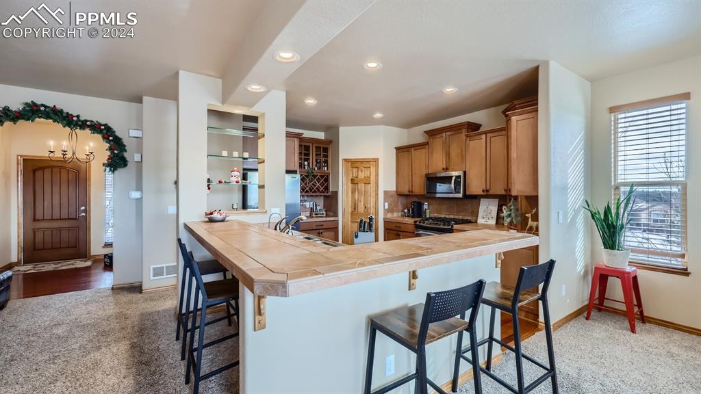 2644 Cinnabar Road Colorado Springs, CO 80921 - Photo 3 of 22 a room with stainless steel appliances kitchen island a table and chairs in it