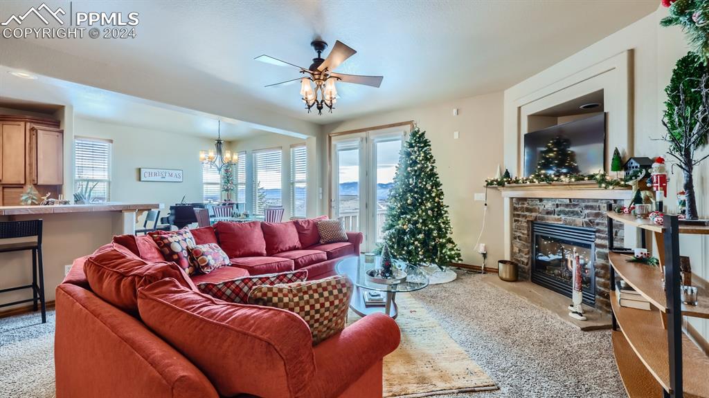 2644 Cinnabar Road Colorado Springs, CO 80921 - Photo 4 of 22 a living room with furniture a chandelier and a flat screen tv