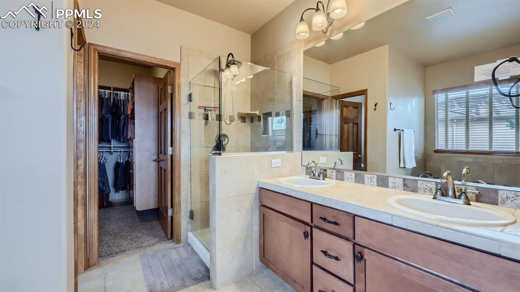 2644 Cinnabar Road Colorado Springs, CO 80921 - Photo 8 of 22 a bathroom with a double vanity sink and a mirror