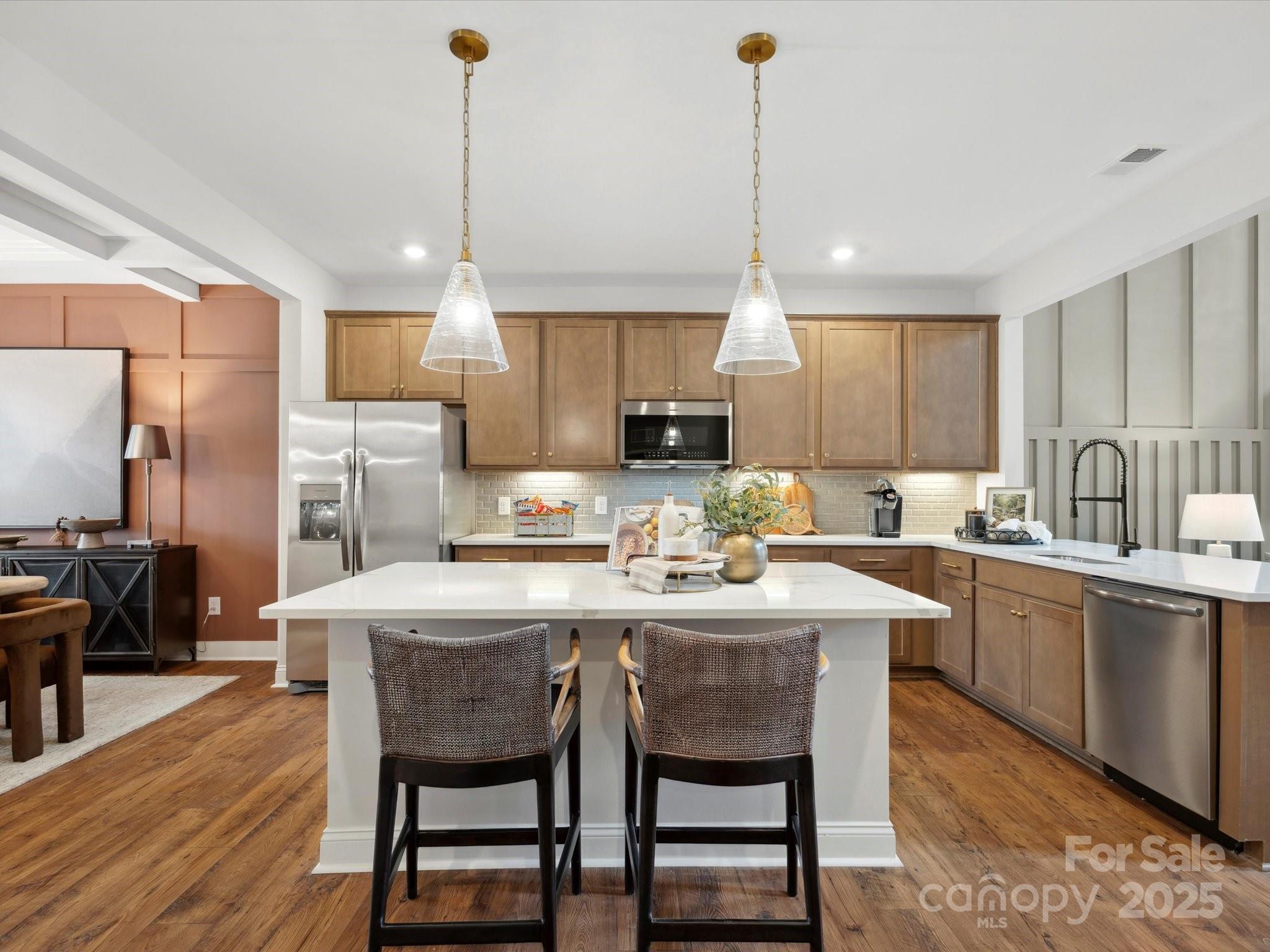 1018 Puddle Pond Road Indian Trail, NC 28079 - Photo 10 of 34 a kitchen with kitchen island a dining table chairs sink and microwave