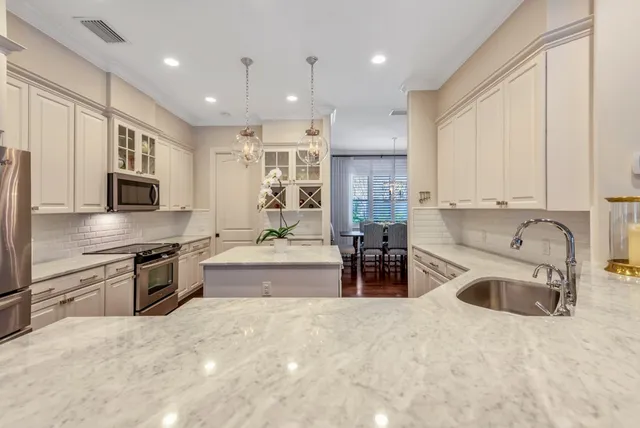 a large kitchen with stainless steel appliances granite countertop a sink stove and refrigerator