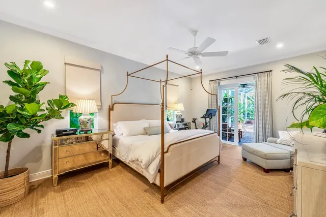 a bedroom with a bed lamp and a potted plant