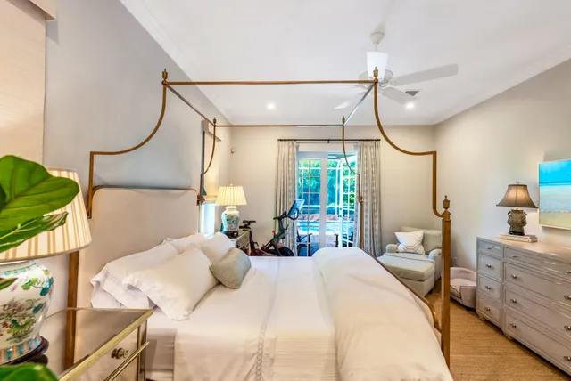 a bedroom with a bed a chandelier and a mirror on the dresser