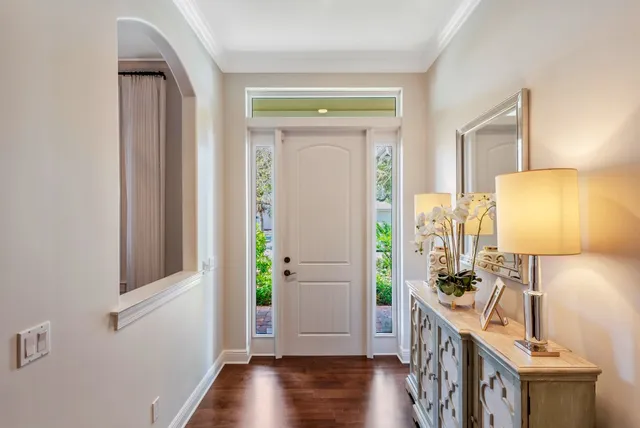 a view of a hallway with wooden floor and a bathroom