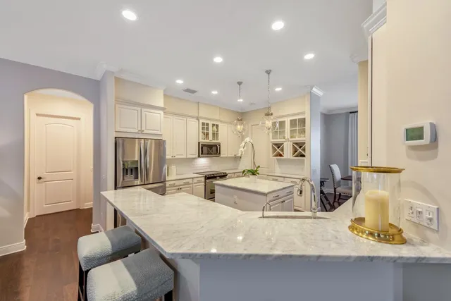 a large kitchen with kitchen island a large counter top space a sink stainless steel appliances and cabinets