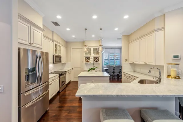 a kitchen with stainless steel appliances granite countertop a sink refrigerator and cabinets