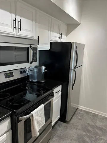 a kitchen with stainless steel appliances a stove a microwave and a refrigerator