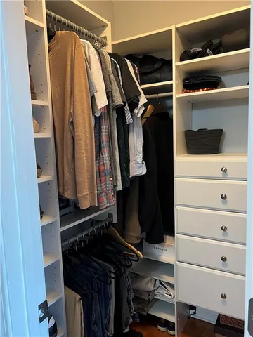a view of walk in closet with clothes and shoes