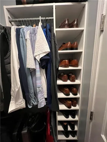 a view of walk in closet with clothes and shoes