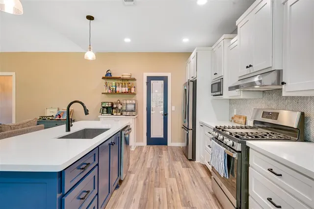 a kitchen with kitchen island a counter space a sink a stove and a window