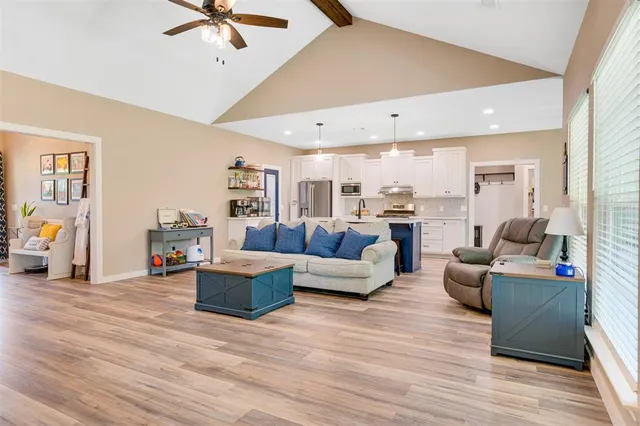 a kitchen with stainless steel appliances kitchen island granite countertop a table chairs refrigerator and microwave